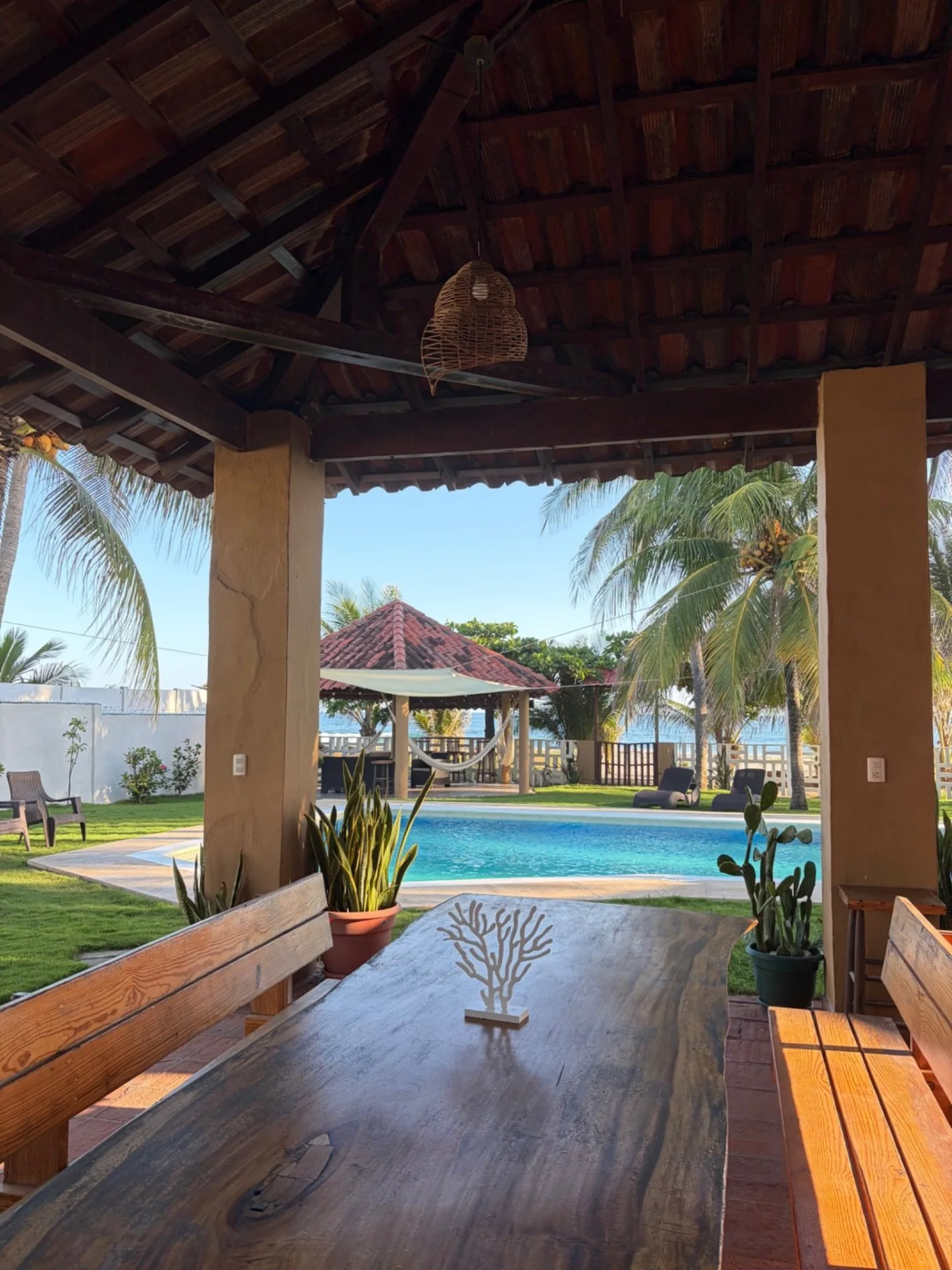 Comedor social con vista abierta hacia la piscina y el mar